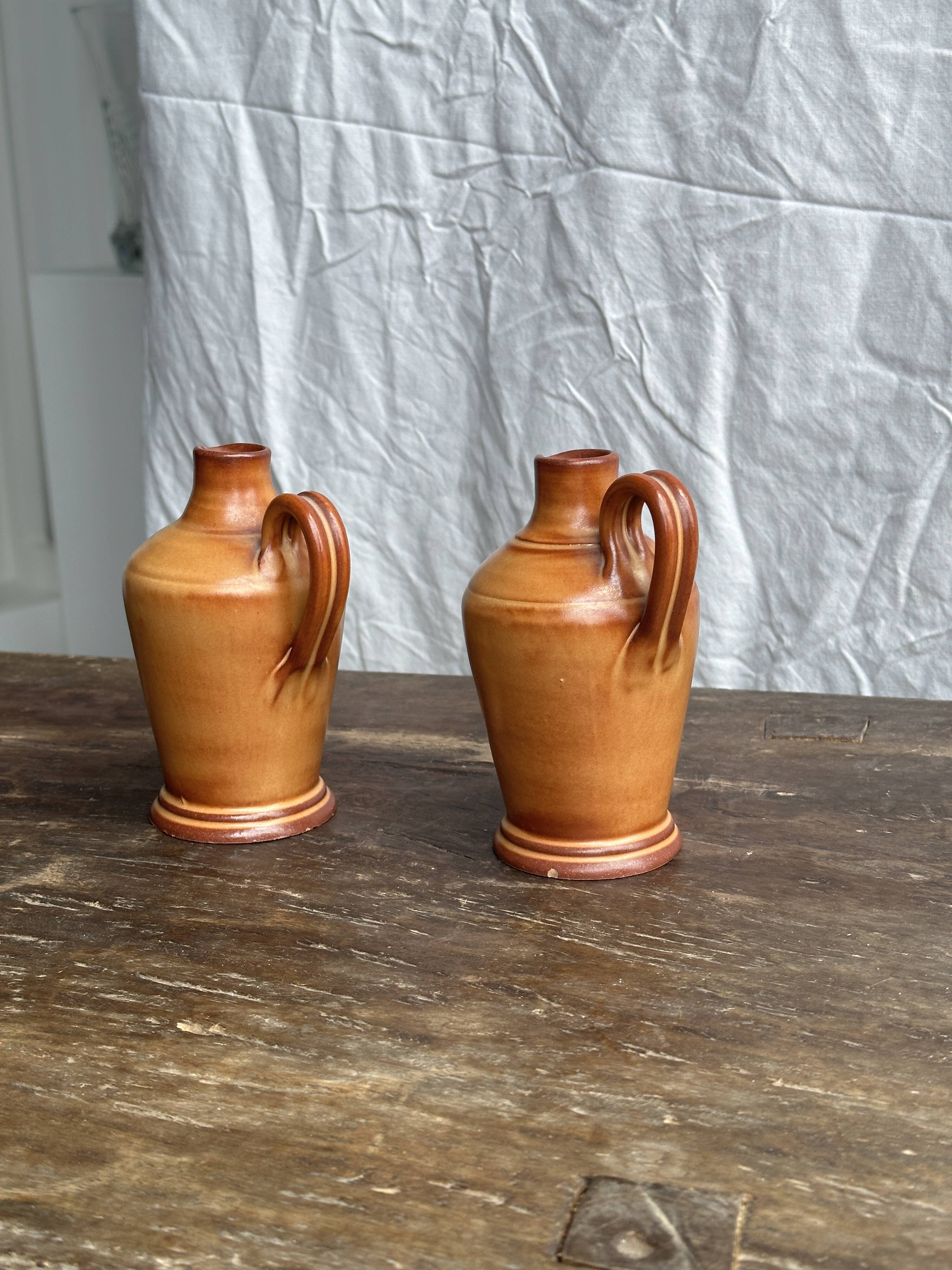 Pair of mini orange stoneware pitchers