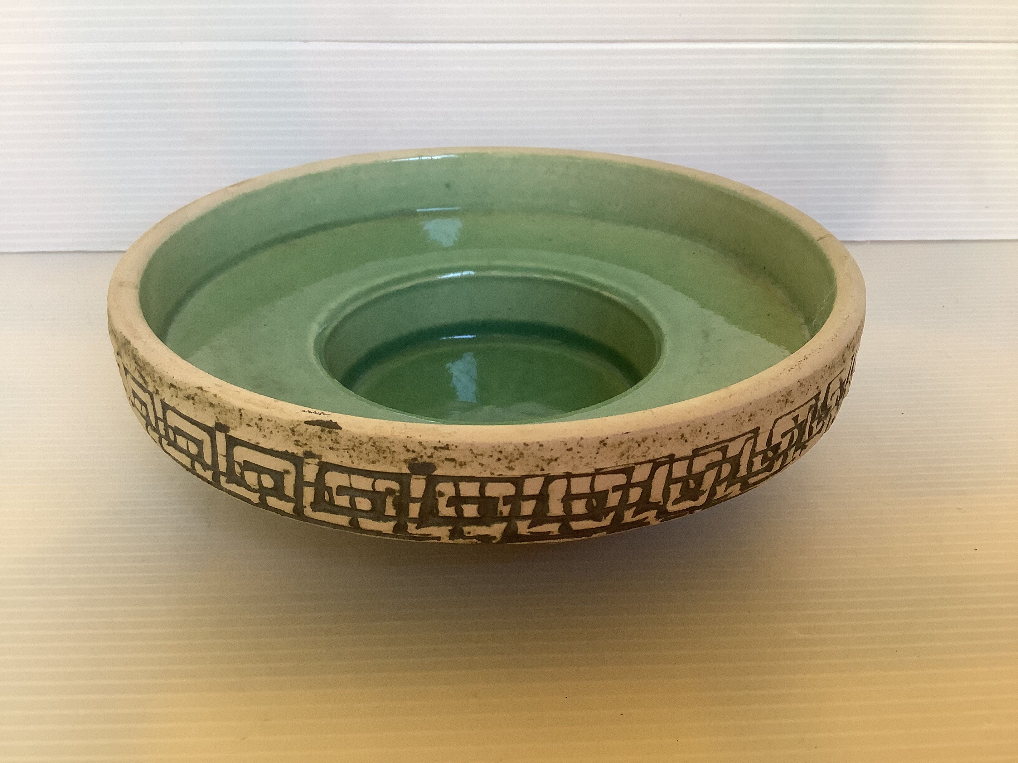 Green ceramic candle holder with a frieze
