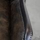 Black cow leather armchair in industrial style finished with decorative nails