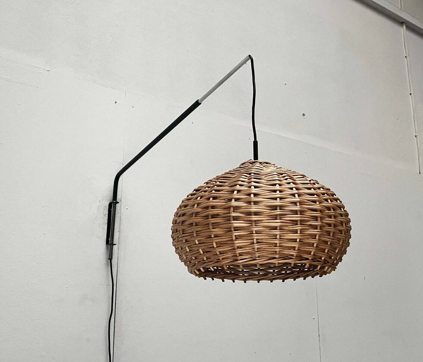 Mid-century modern Danish extendable cantilever wall lamp with a rattan shade, 1960s.