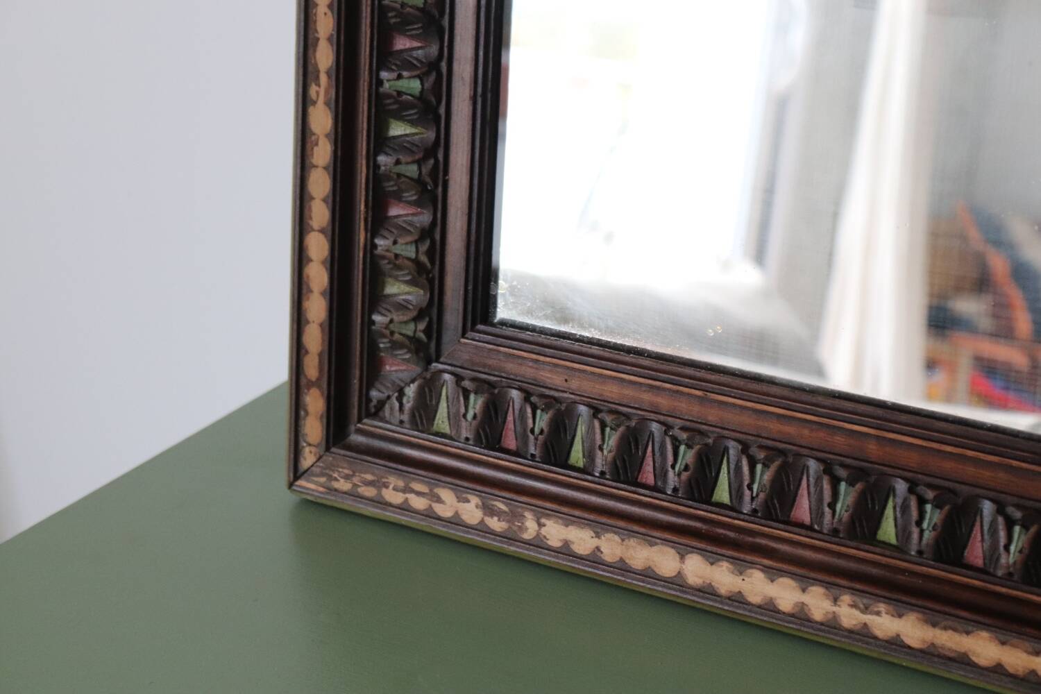 Antique mirror with a carved and painted wooden frame