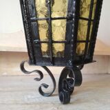 Large hanging lantern in wrought iron and opaque yellow-orange windows
