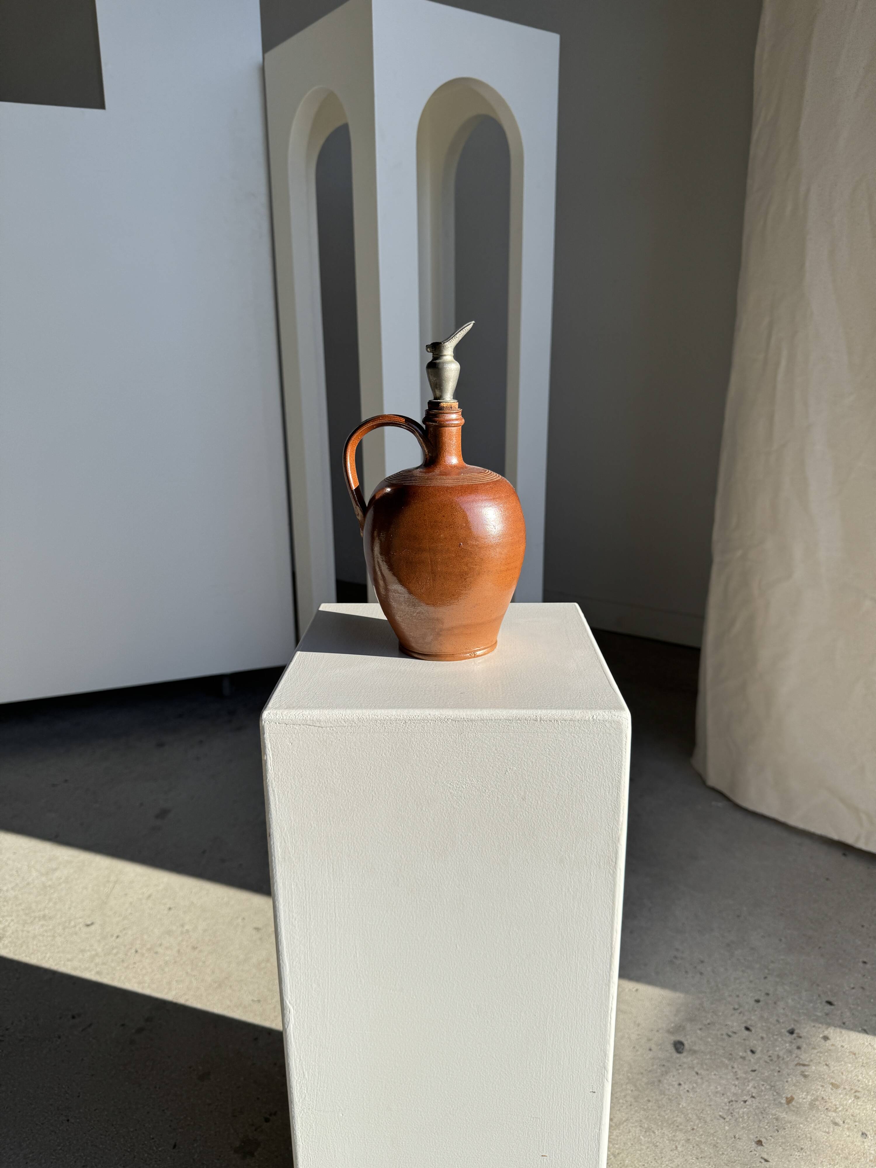 Ancient stoneware jug with a pewter spout.