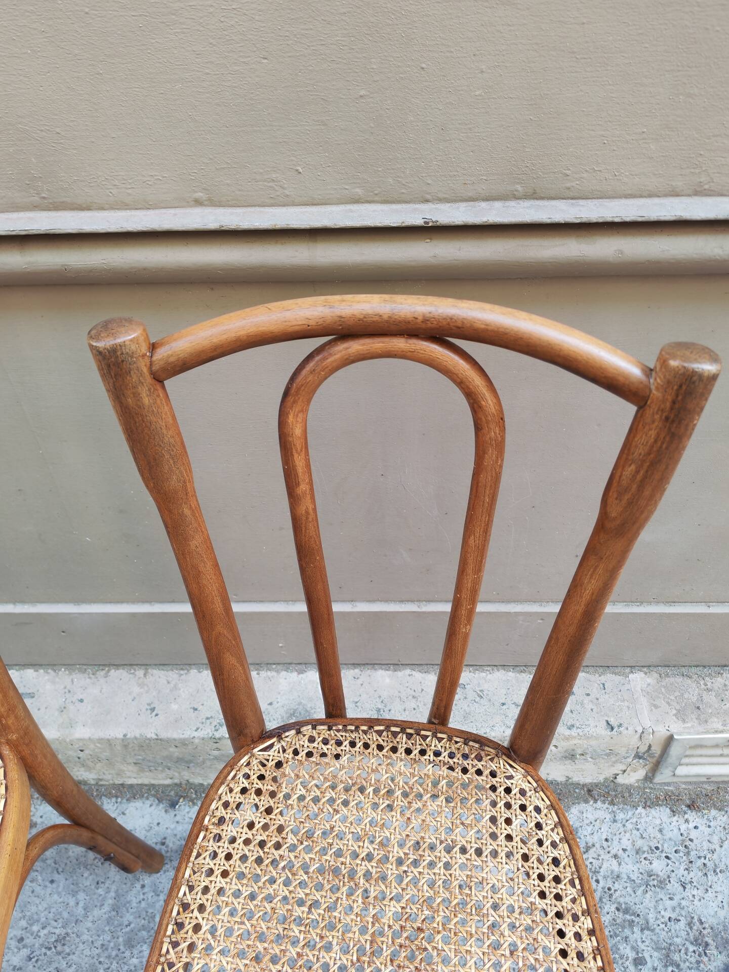 Pair of vintage bistro chairs in curved wood and caning.