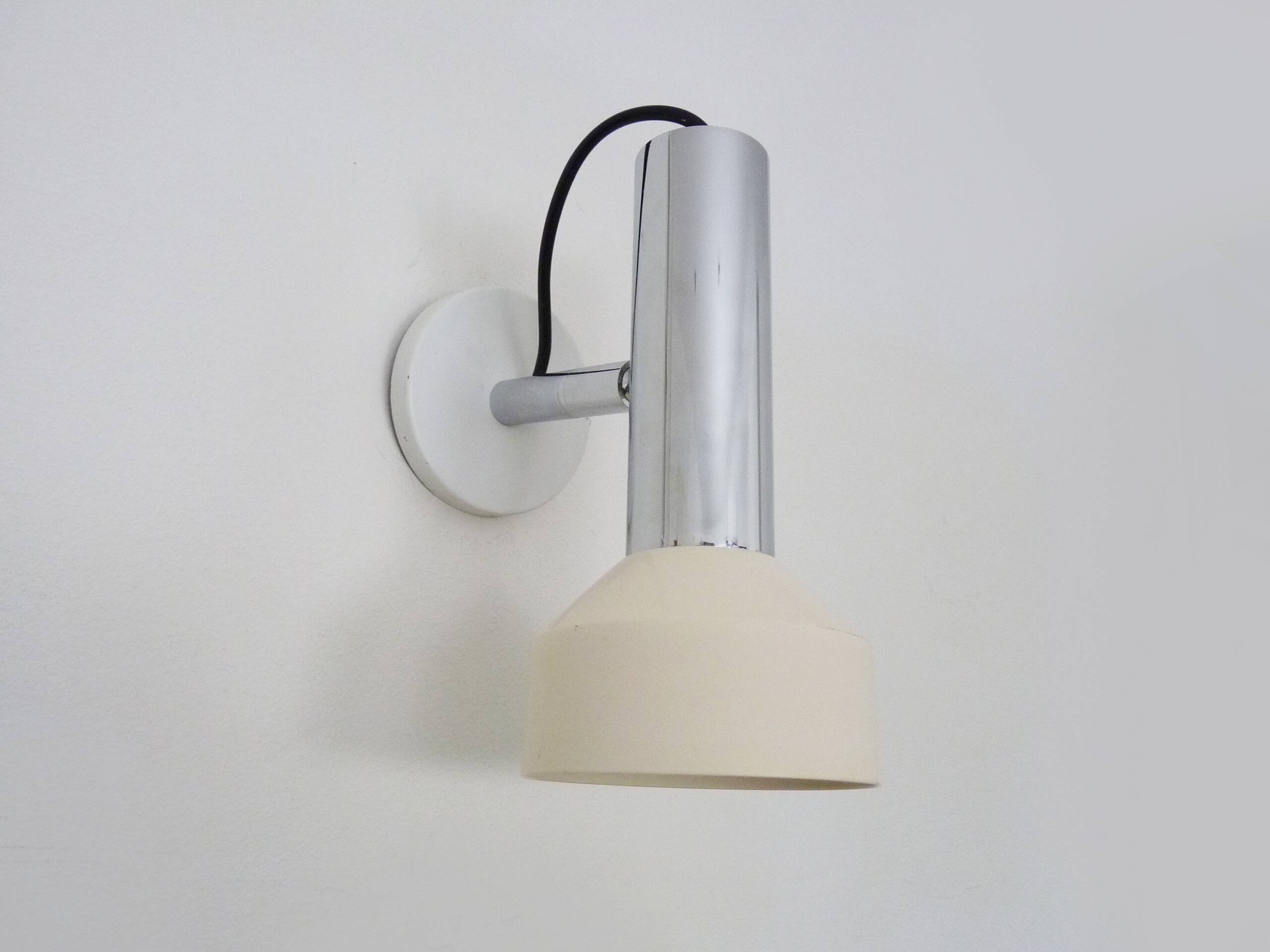 Adjustable wall spotlight in chrome-plated and white lacquered metal. 1970s