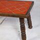 Brutalist coffee table in orange ceramic and solid wood.