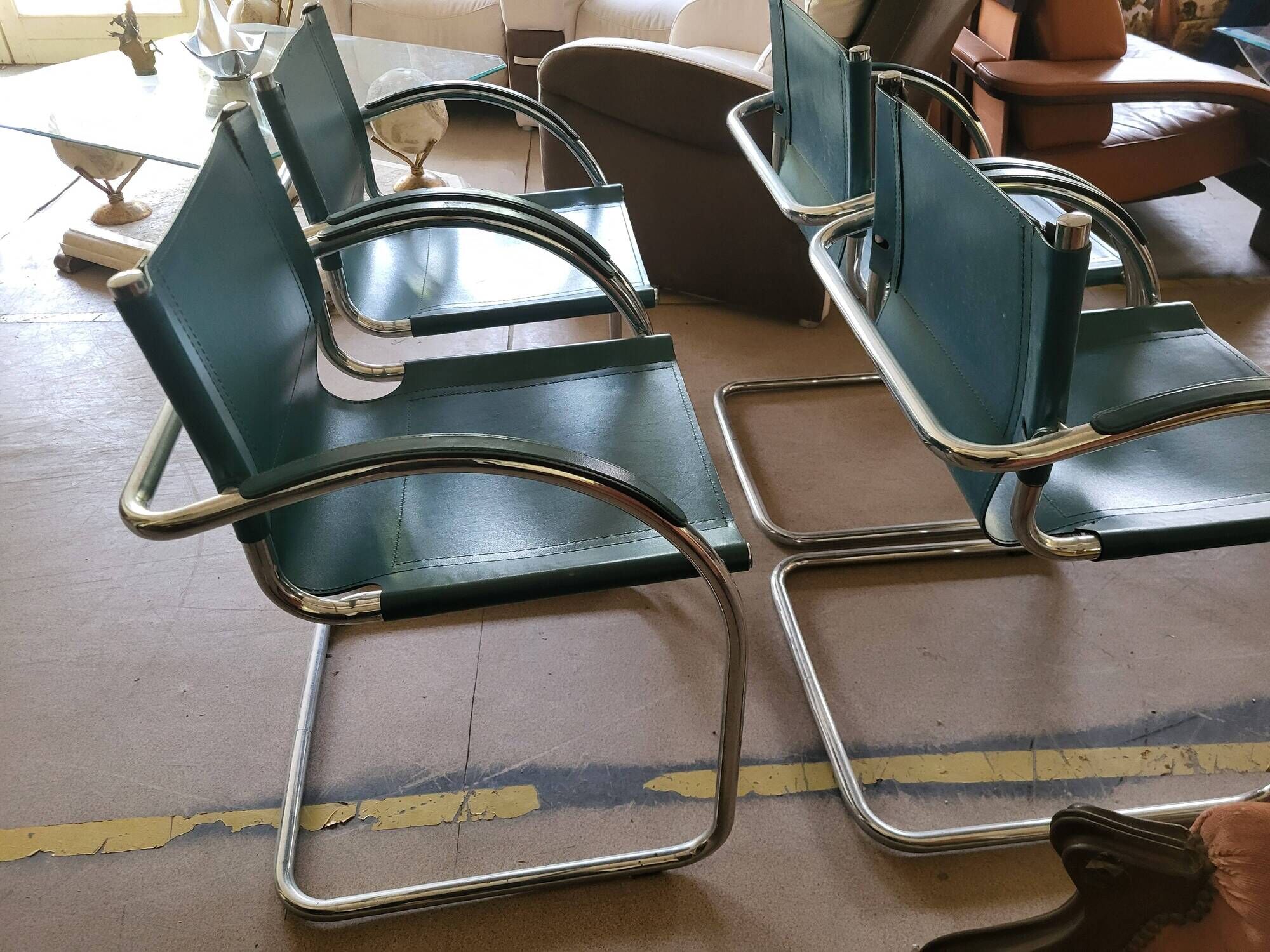 4 vintage Italian armchairs in green leather and chrome metal.