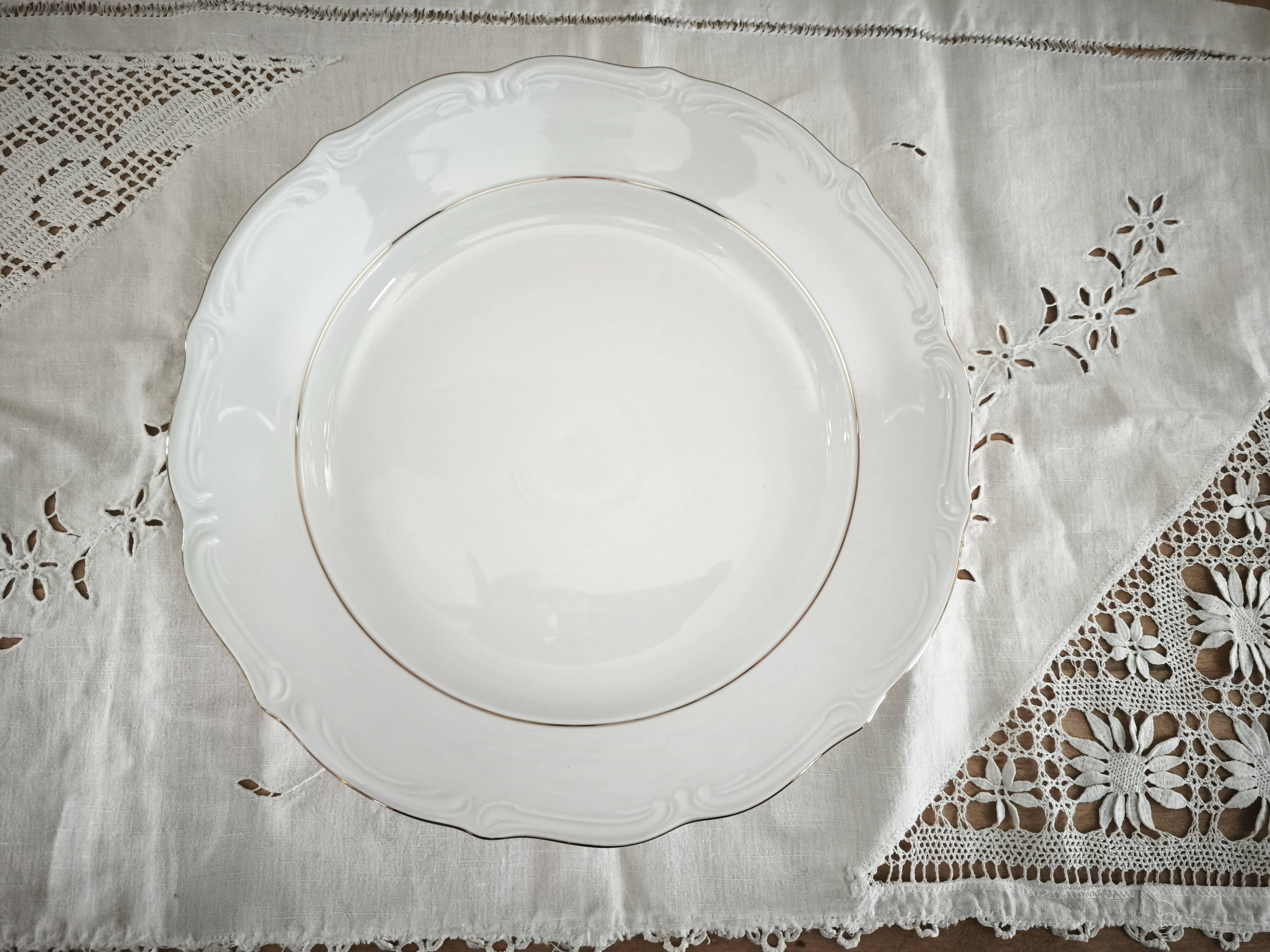 Hollow round plate in porcelain, double gold rim manufacture.