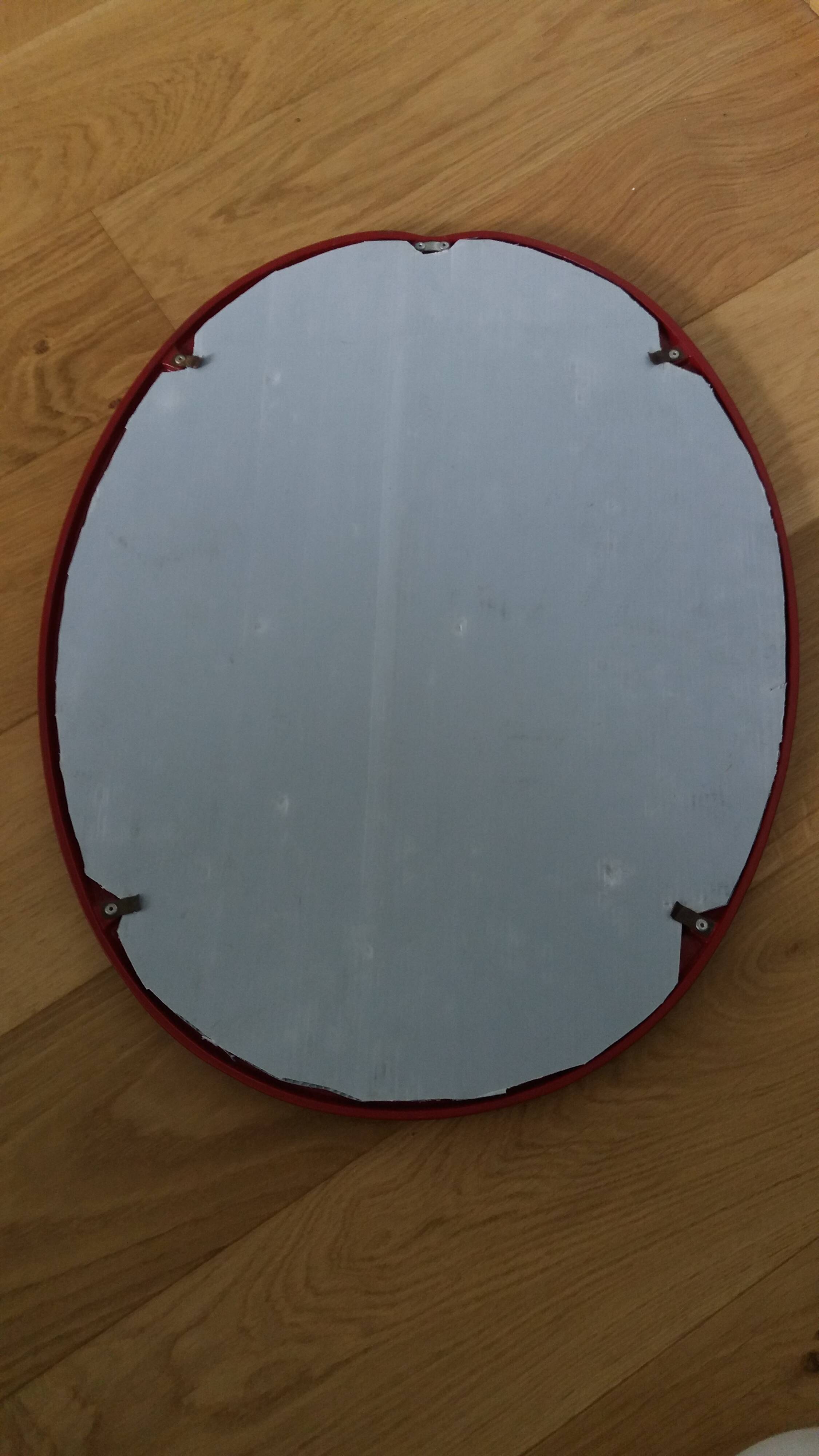 Oval mirror, red enamelled metal in Art Deco style, 49 x 39 cm.