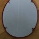 Oval mirror, red enamelled metal in Art Deco style, 49 x 39 cm.