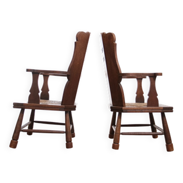 Pair of brutalist oak lounge chairs with rush seats, circa 1935