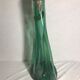 Old green molded glass bottle with rounded shape