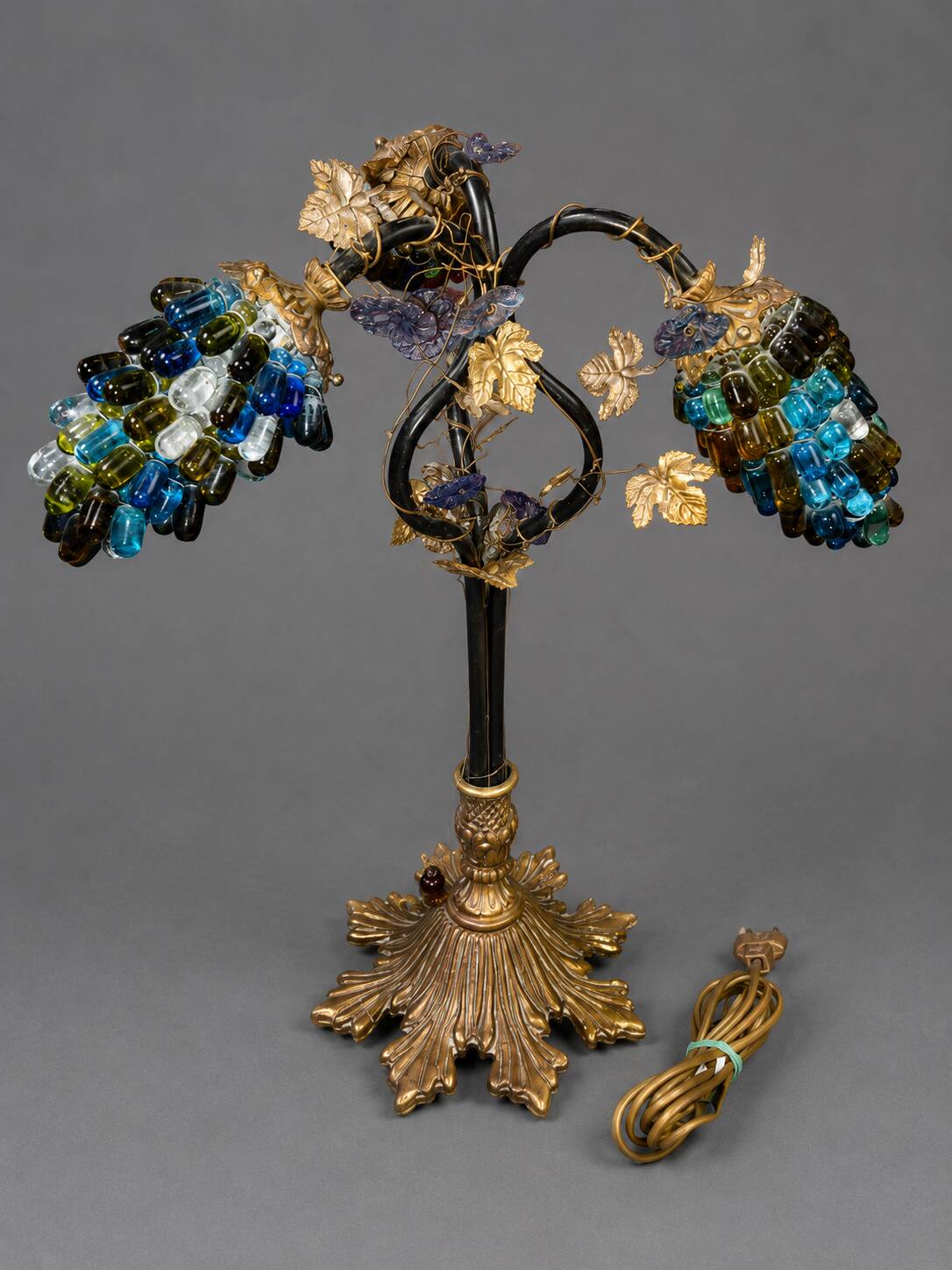 Decorative table lamp in the shape of coloured glass grape clusters.