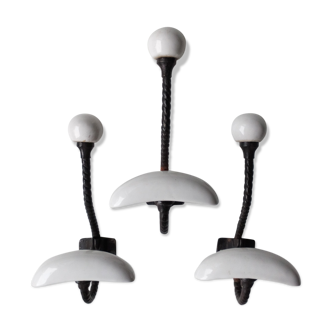 Trois patères doubles en fer forgé et porcelaine