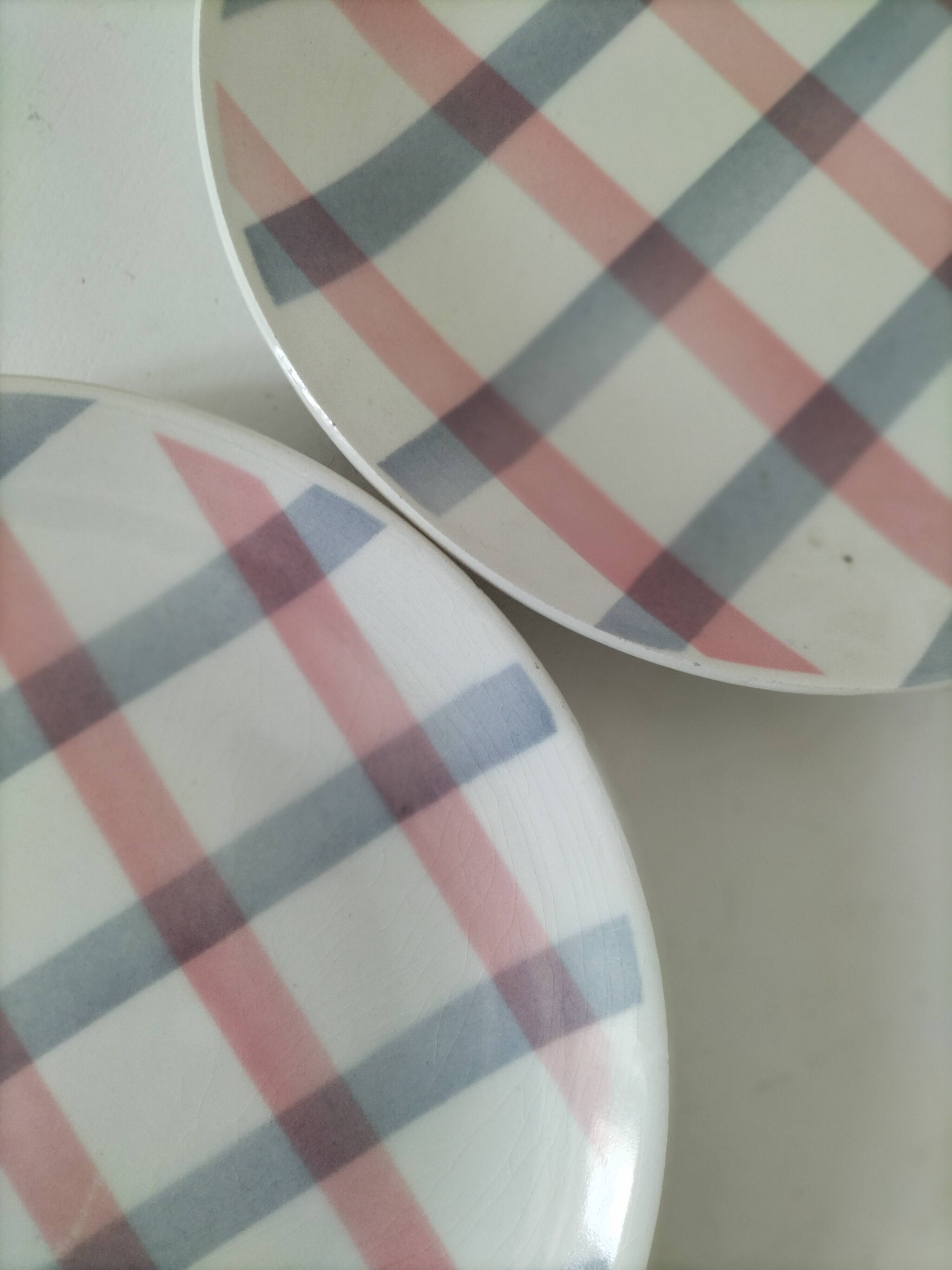 Two dessert plates Moulin des Loups with a pink and grey tablecloth design.
