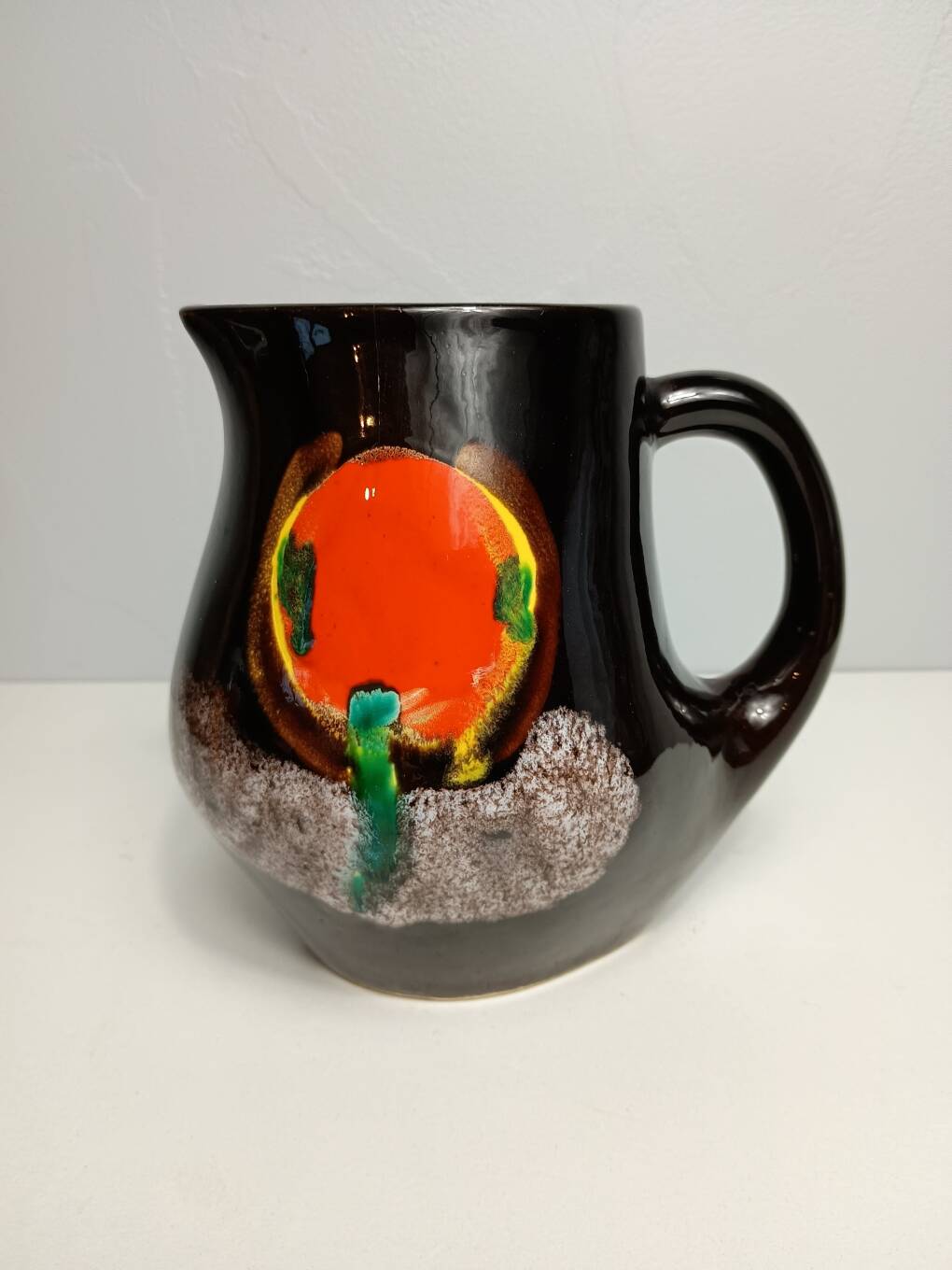 Brown ceramic pitcher with coloured patterns signed Bresse.