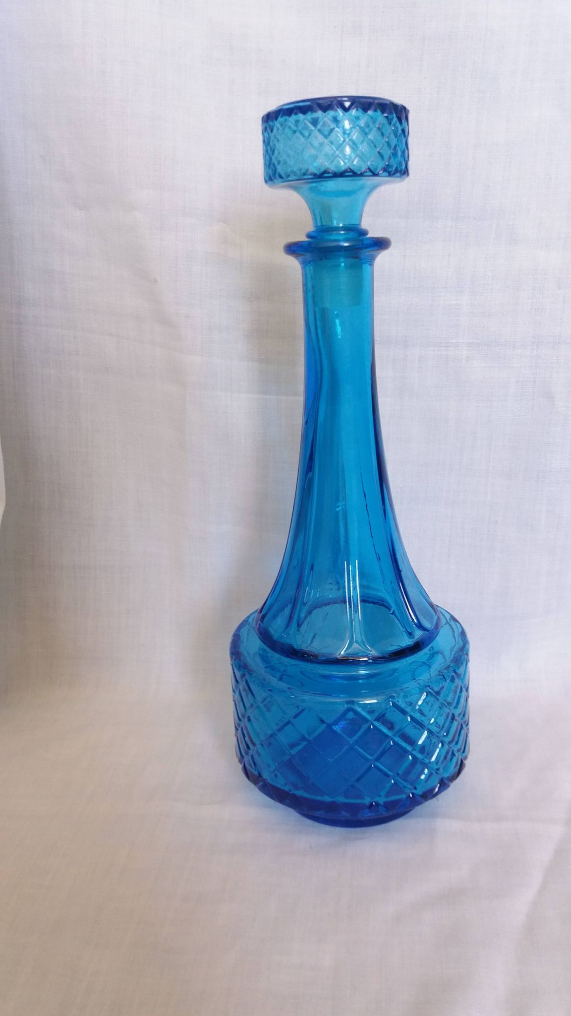 Turquoise glass carafe bottle with a stopper.