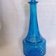 Turquoise glass carafe bottle with a stopper.