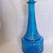 Turquoise glass carafe bottle with a stopper.