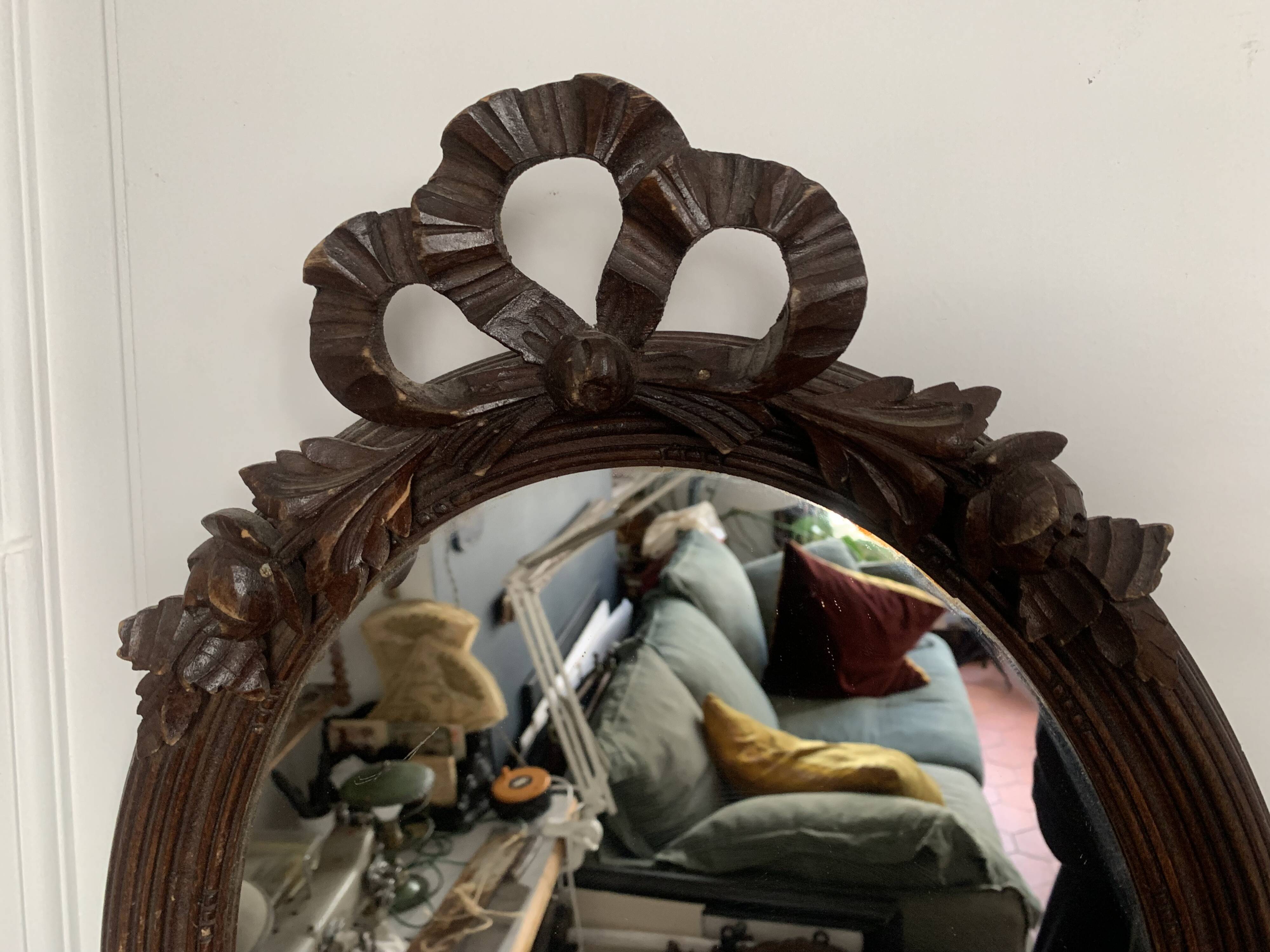 Antique oval mirror in carved wood and Louis XVI style knot