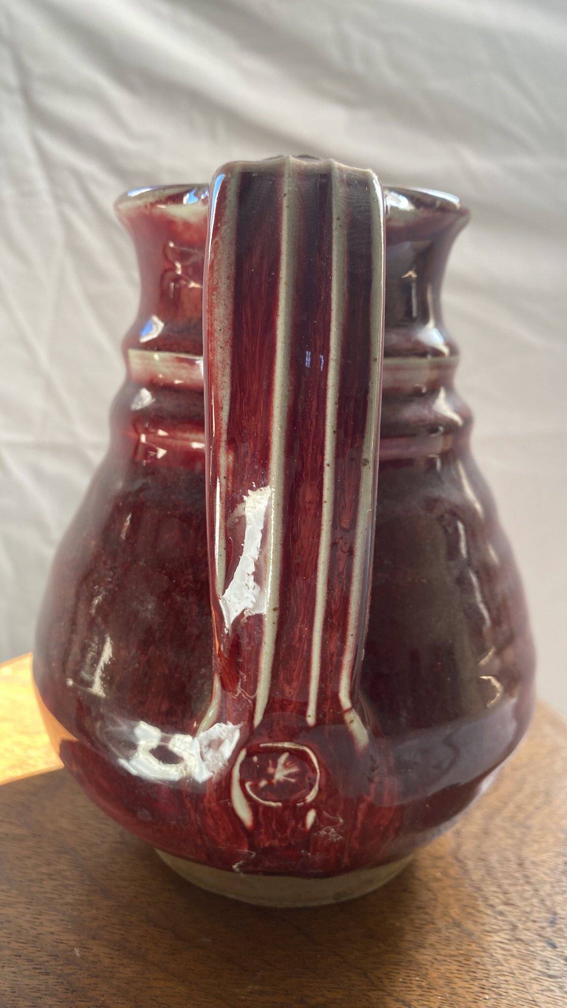 Oxblood pitcher with grotesque mask in the Delplera spirit