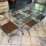 Wrought iron table with duckbill profile glass top and 6 armchairs