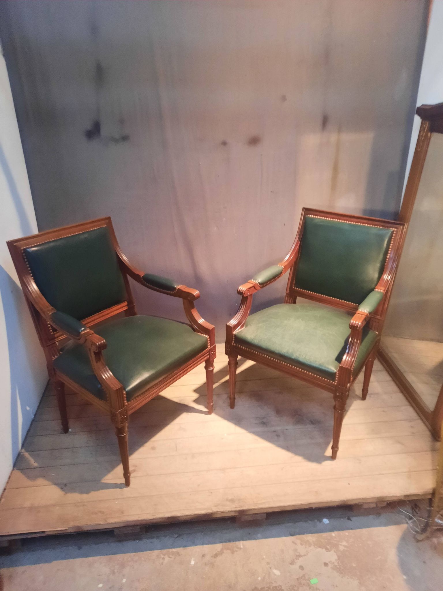 Pair of Louis XVI style armchairs upholstered in green leather.
