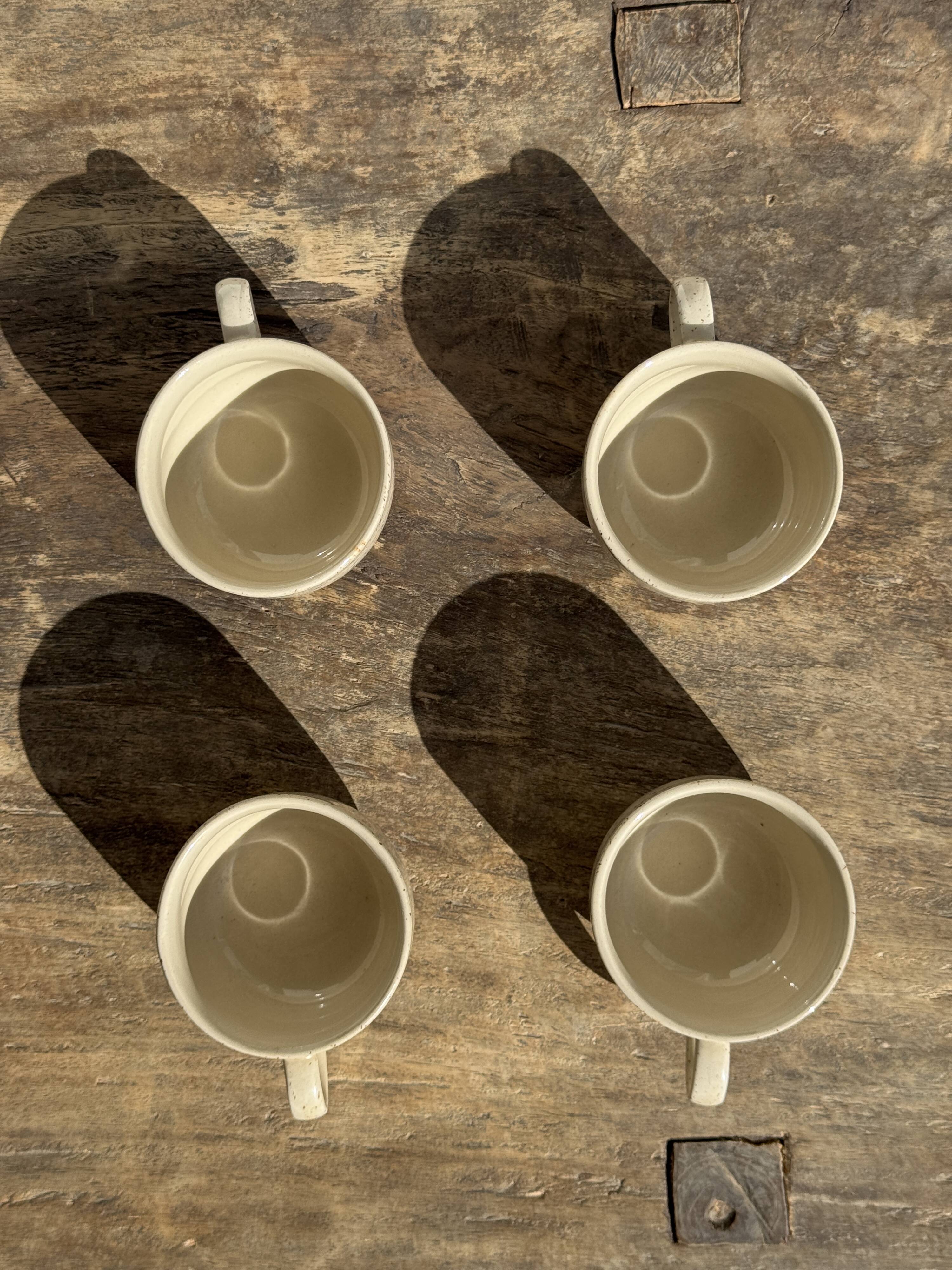 Set of 4 vintage speckled beige stoneware coffee cups.