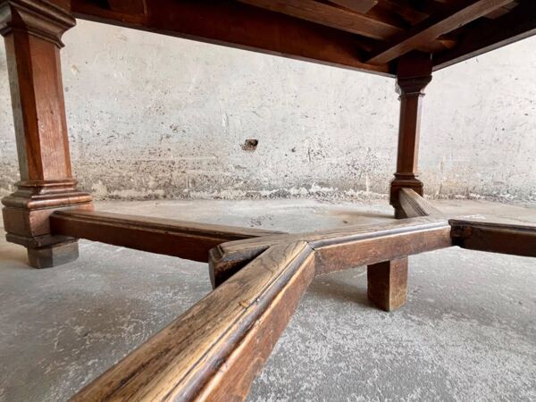 Table à manger carrée en bois massif brun foncé de style néo-Renaissance avec base en croix.
