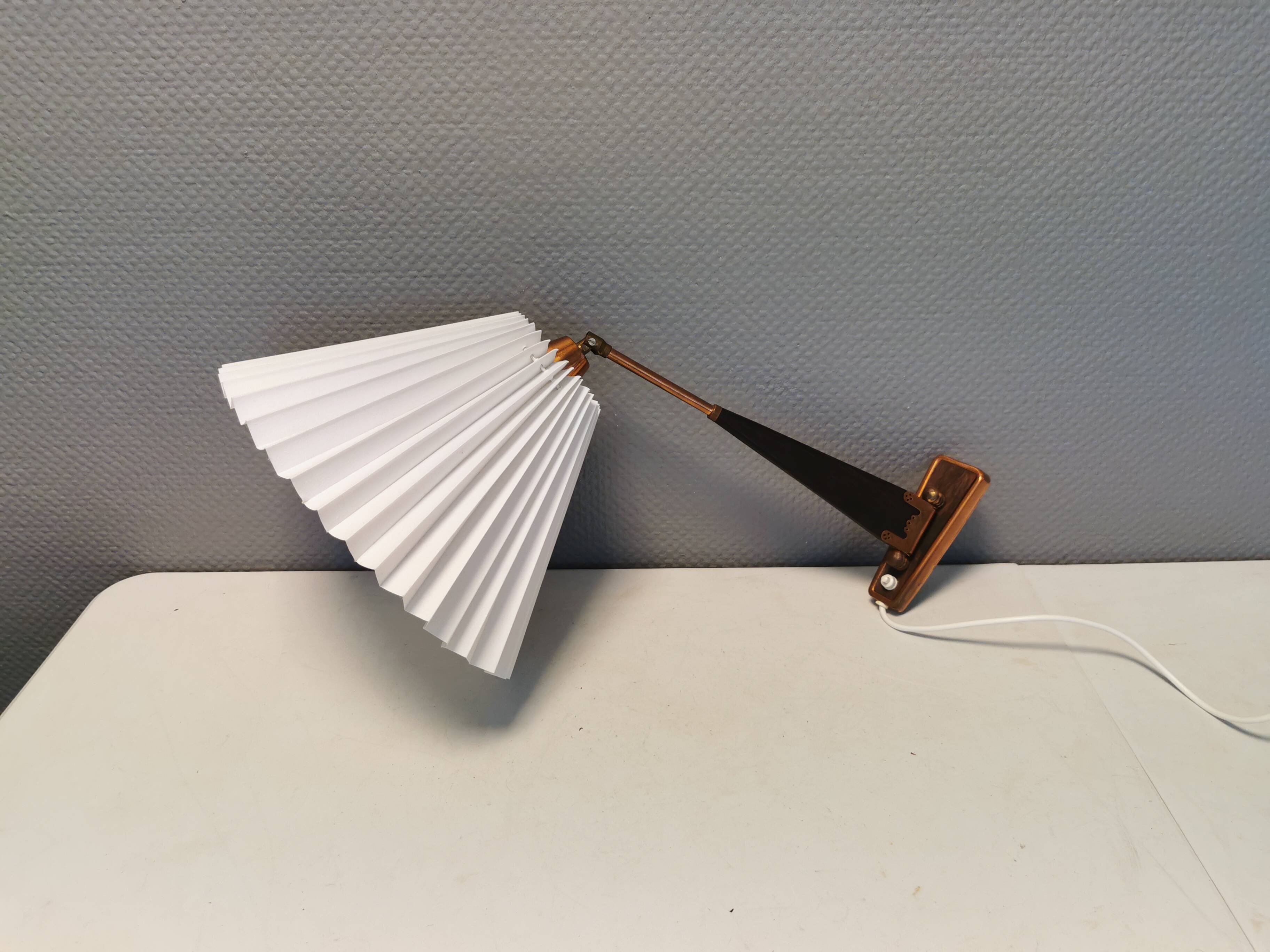 Wall lamp with adjustable ‘arm’ in copper and rosewood, with white shade.