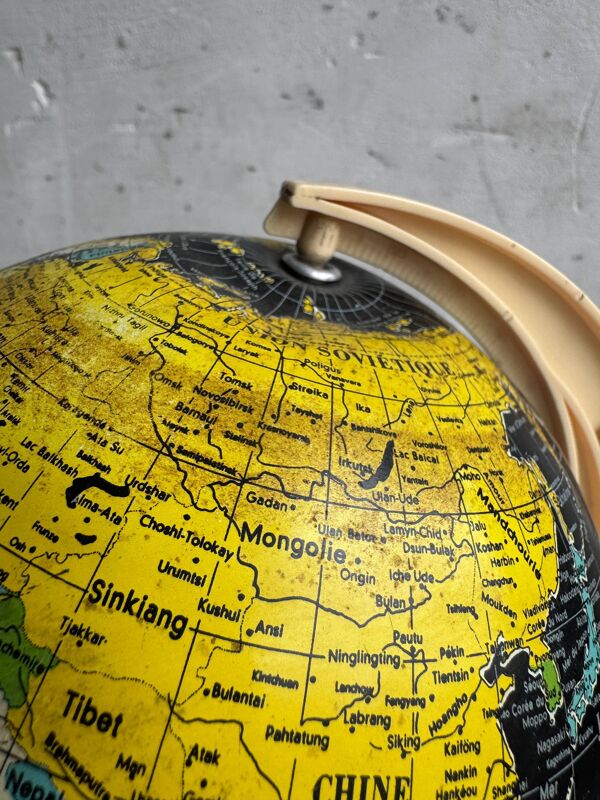 Globe terrestre scolaire français du milieu du XXe siècle, avec des océans noirs sur papier imprimé et un socle en plastique crème.