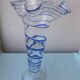 Glass vase on a pedestal with a blue trim.