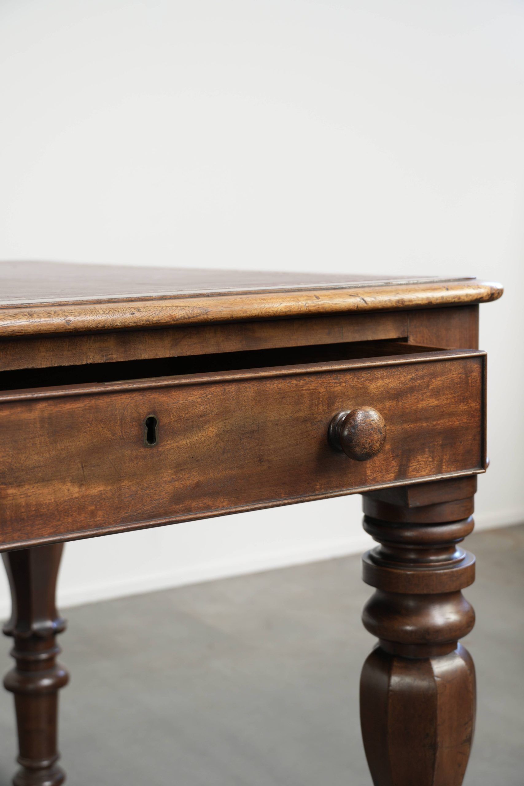 Antique English writing desk from the 19th century with a red leather top