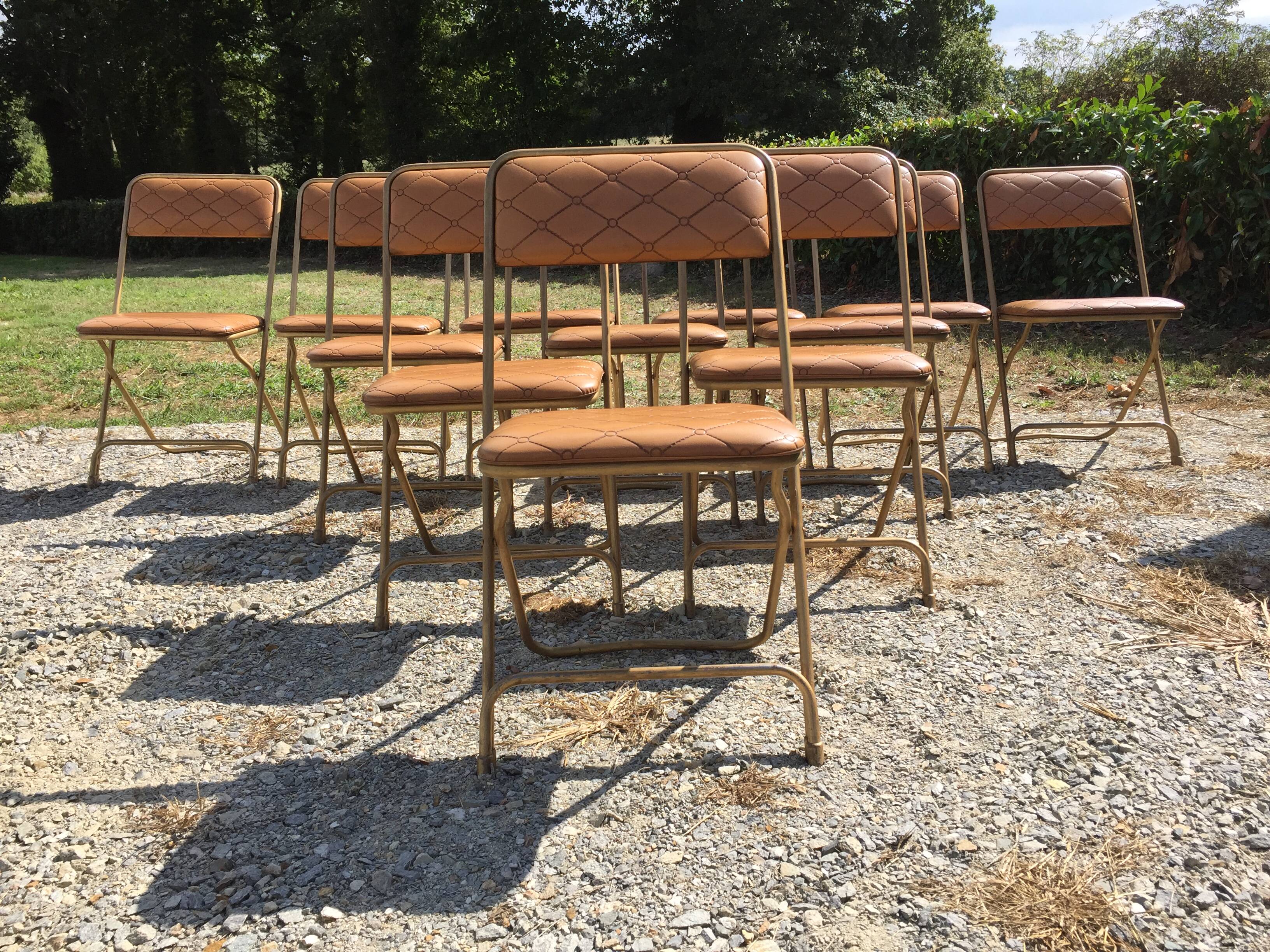 Set de 12 chaises vintage pliantes en skaï assises et dossiers matelassés à piètement tubulaire doré