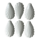 Set of white porcelain ramekins, ribbed shell shape.