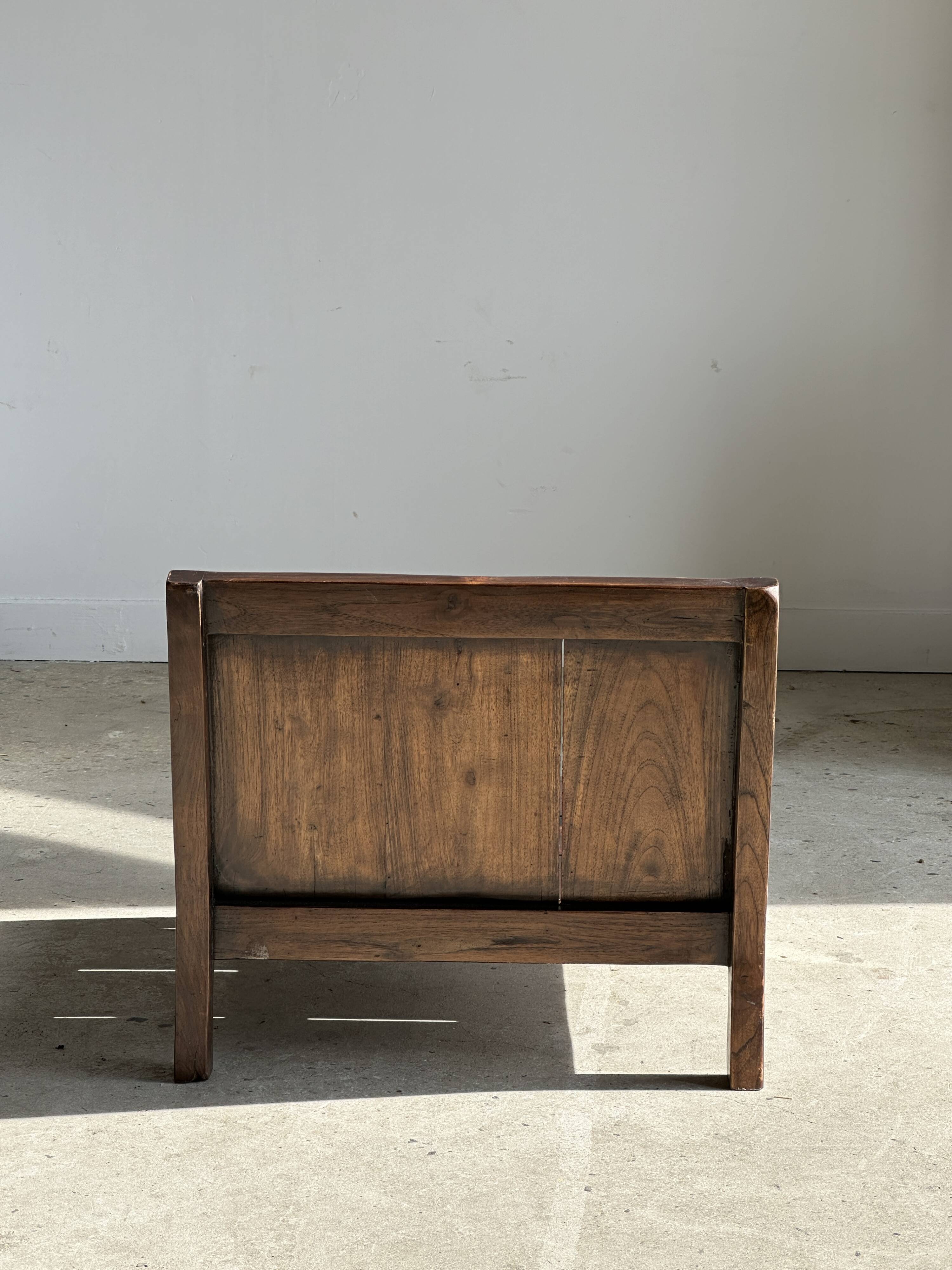 Small low armchair in varnished brown wood
