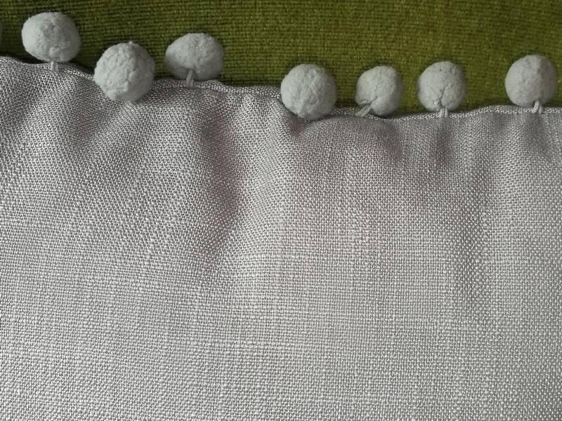 Gray cushion with pompoms