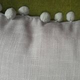 Gray cushion with pompoms