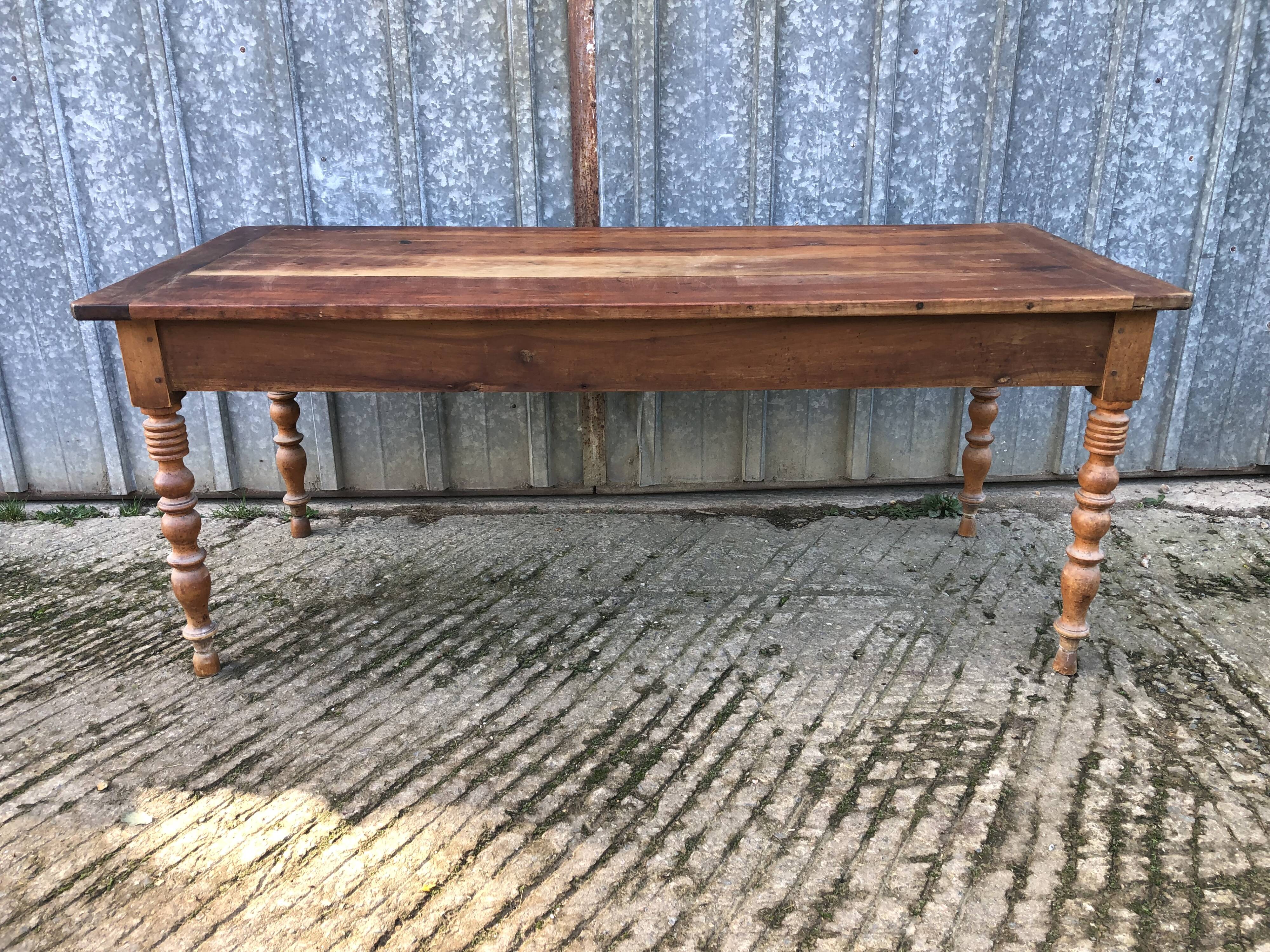 Antique farmhouse table in solid cherry wood with turned legs.