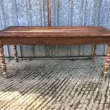 Antique farmhouse table in solid cherry wood with turned legs.