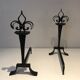 Important pair of wrought iron andirons with torch in heraldic fleur-de-lis design.