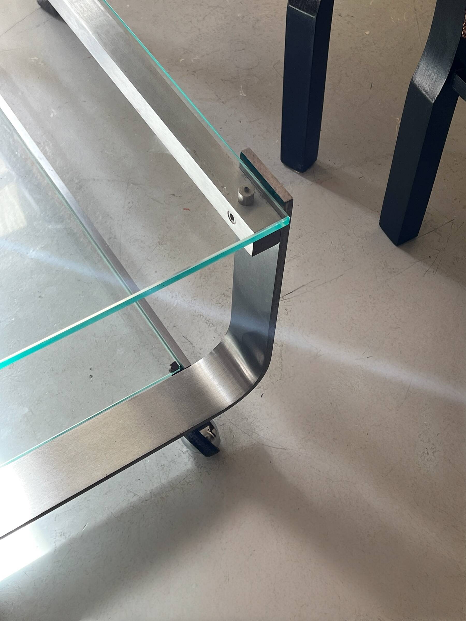 Brushed chrome coffee table with glass, 2 tiers on wheels, 1970s design.