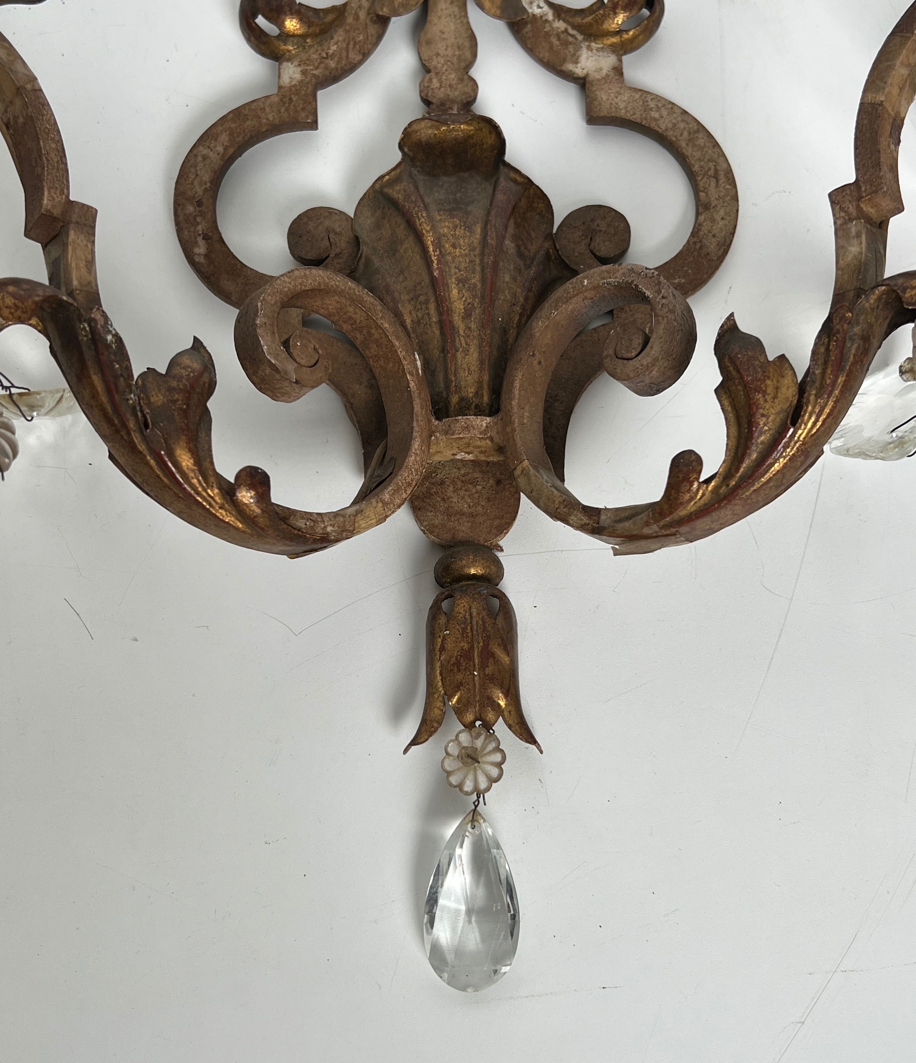 Pair of patinated wrought iron wall sconces with golden acanthus leaves and crystals.