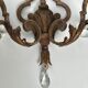 Pair of patinated wrought iron wall sconces with golden acanthus leaves and crystals.