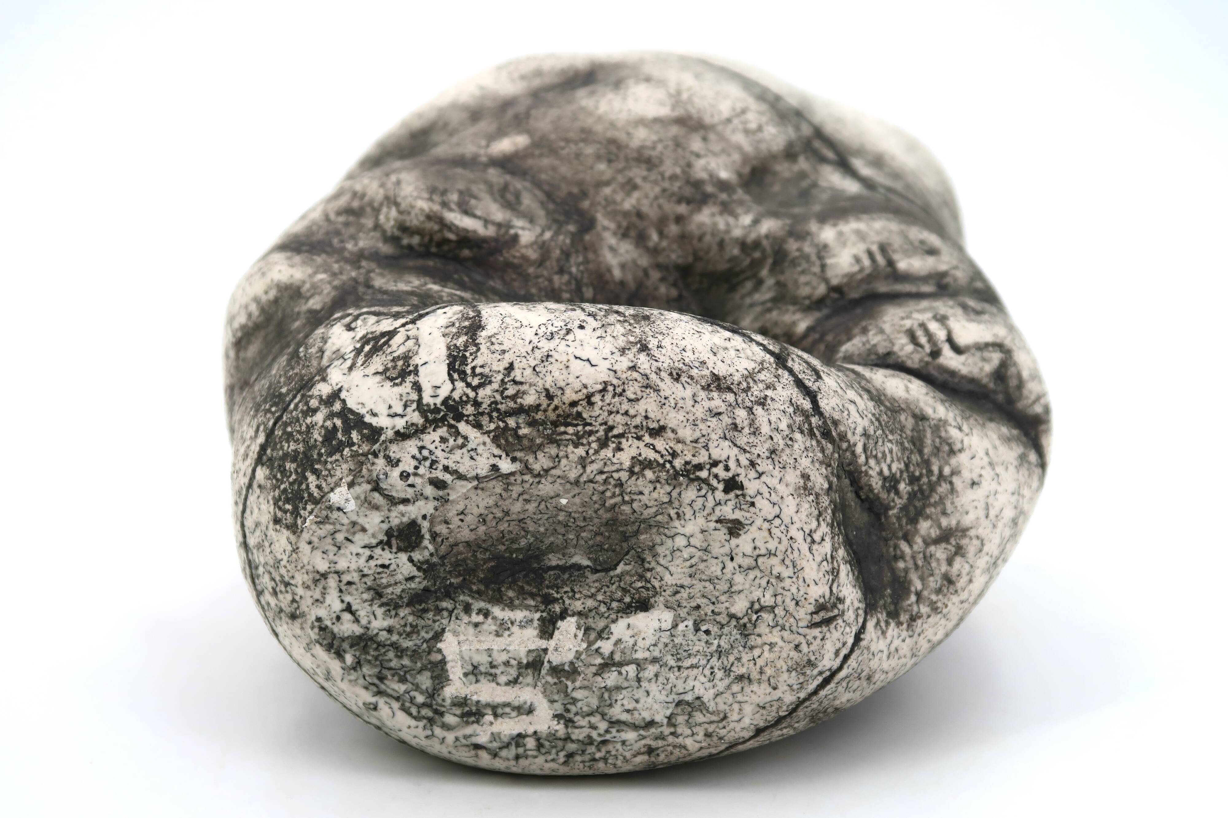 Ceramic vase sculpture decorated with faces and featuring a hole, 1980s.