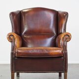 Comfortable, elegant, stately wing chair made of sheepskin in a beautiful warm color