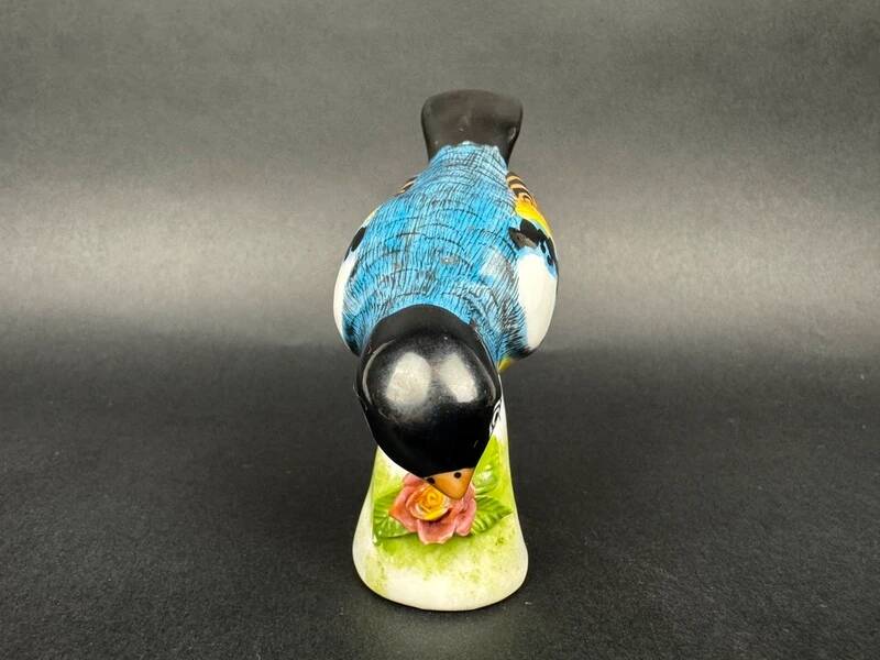 Porcelain figurine of a polychrome bird on a vintage floral base
