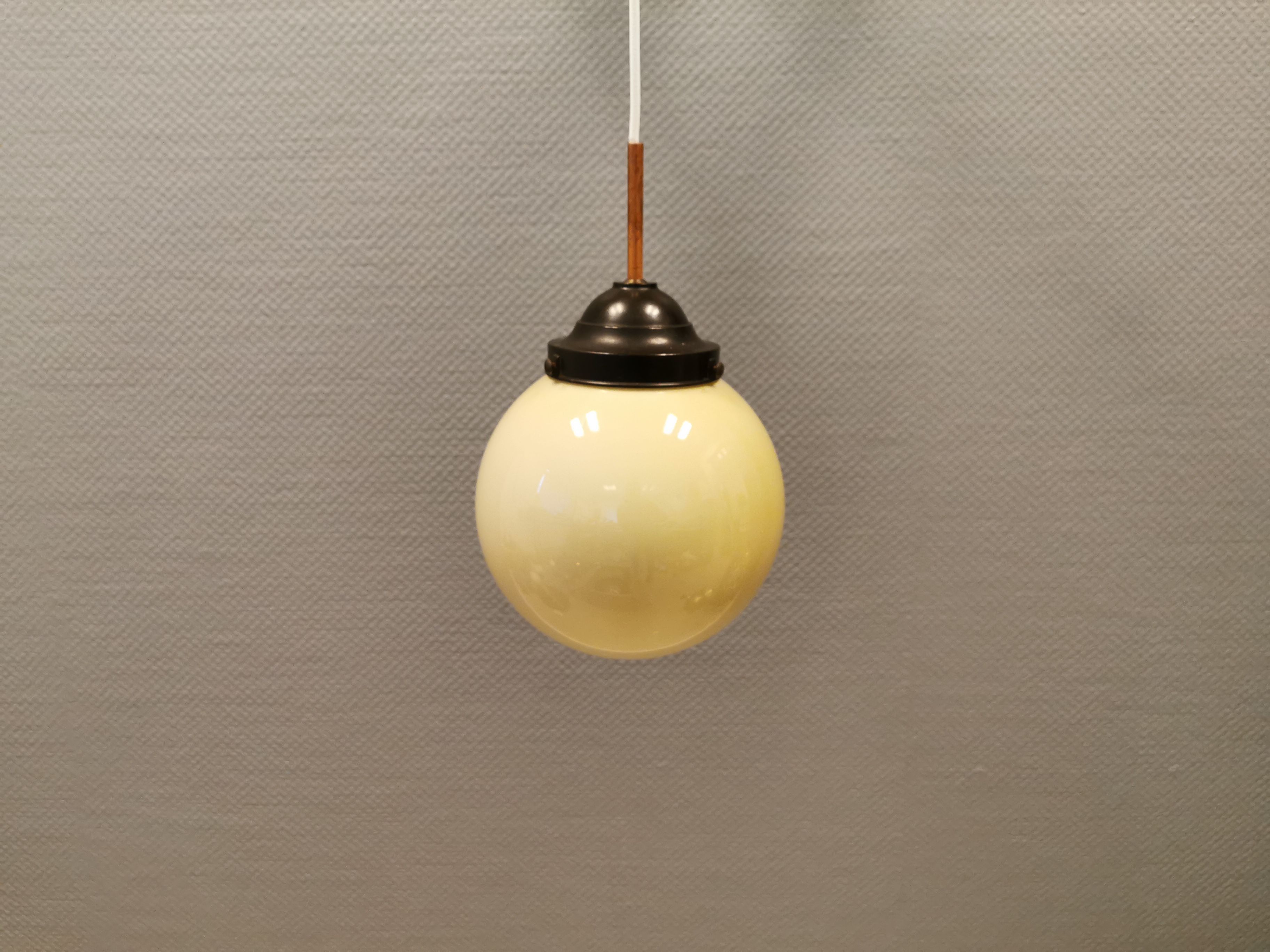 Small Art Deco hanging lamp in cream coloured glass and bakelite top.