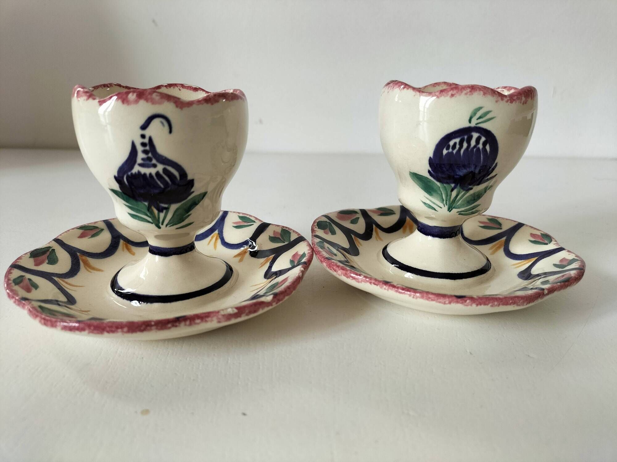 Pair of HB Quimper egg cups with integrated pedestal base, floral decoration