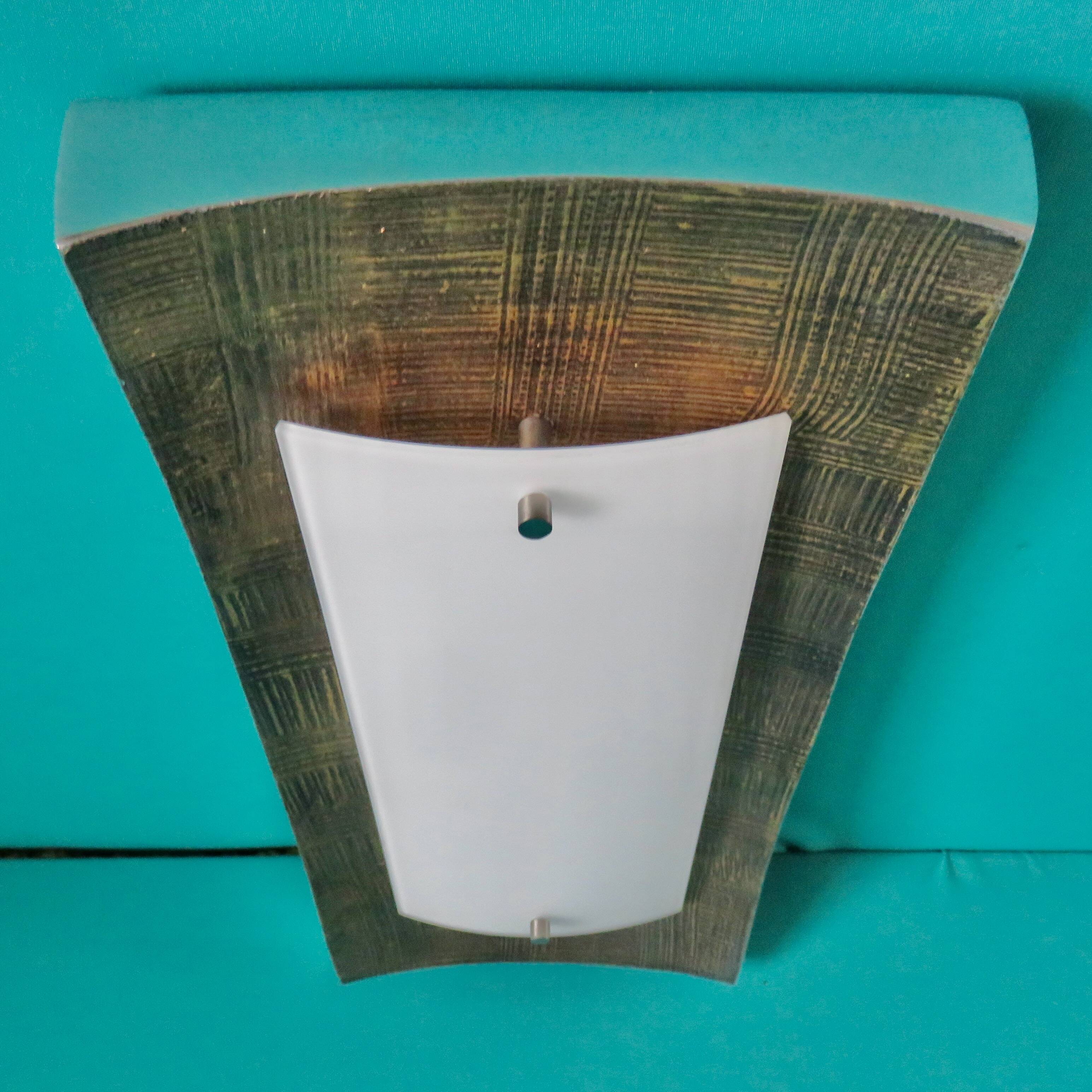 Pair of wall sconces in gold-plated alloy with bas-relief and opaline glass. Germany, 1980